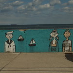 Graffiti na Bulwarze Nadmorskim w Gdyni. Marynarze, dziewczyna i żaglówki na morzu