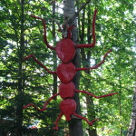 Rzeźba w postaci olbrzymiego czerwonego owada na drzewie w Bystrem, niedaleko cerkwi